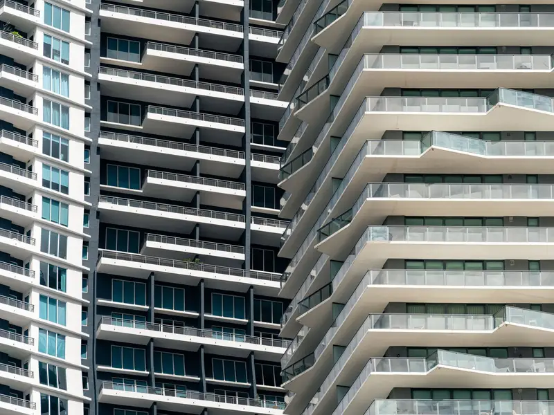 A high-rise condominium tower with rows of curved balconies
